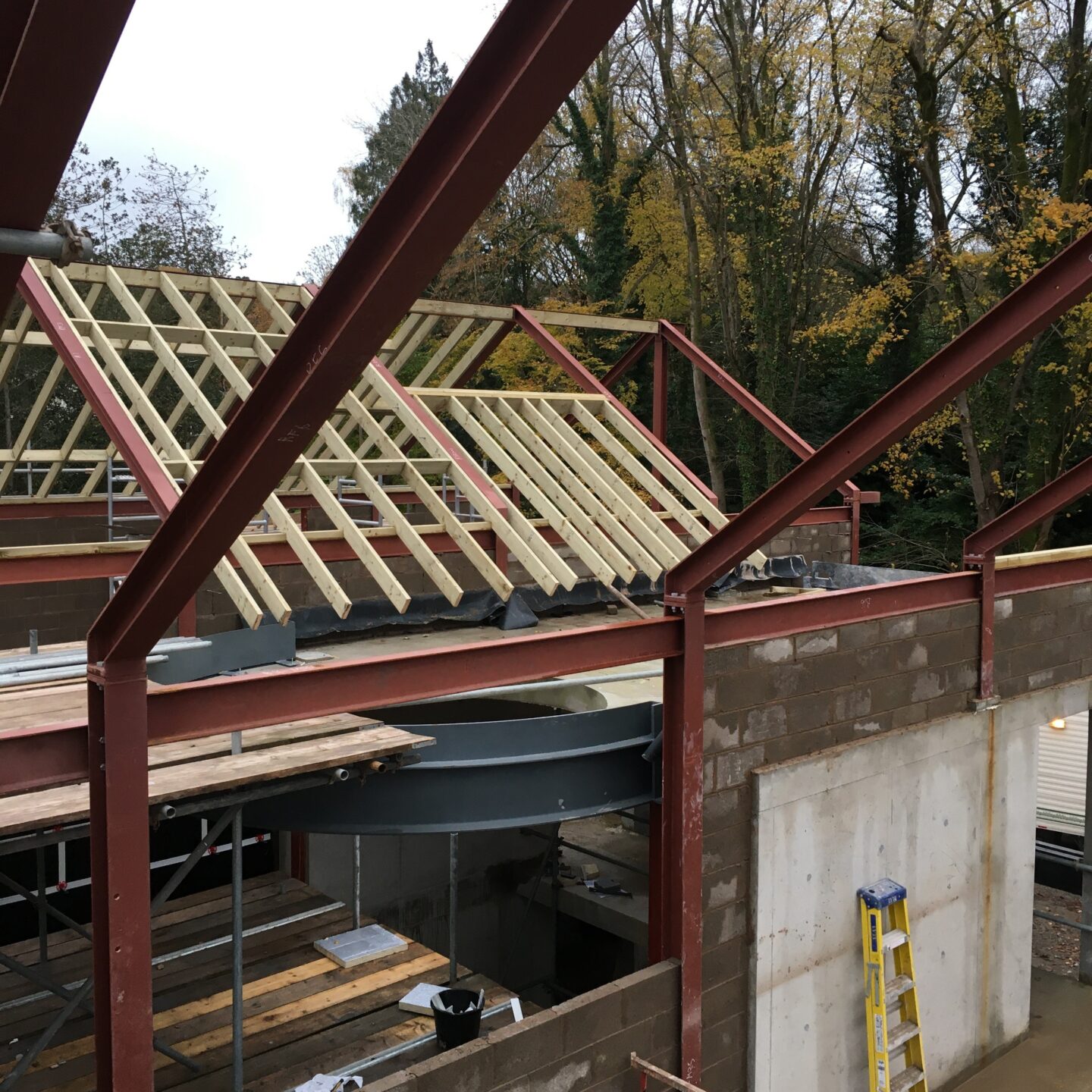 View from inside a construction site, showing a large residential house complex being built.