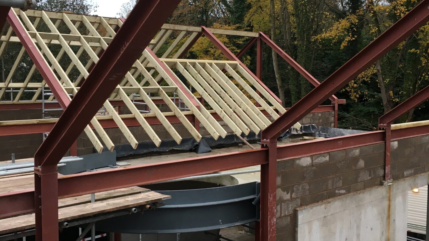 View from inside a construction site, showing a large residential house complex being built.